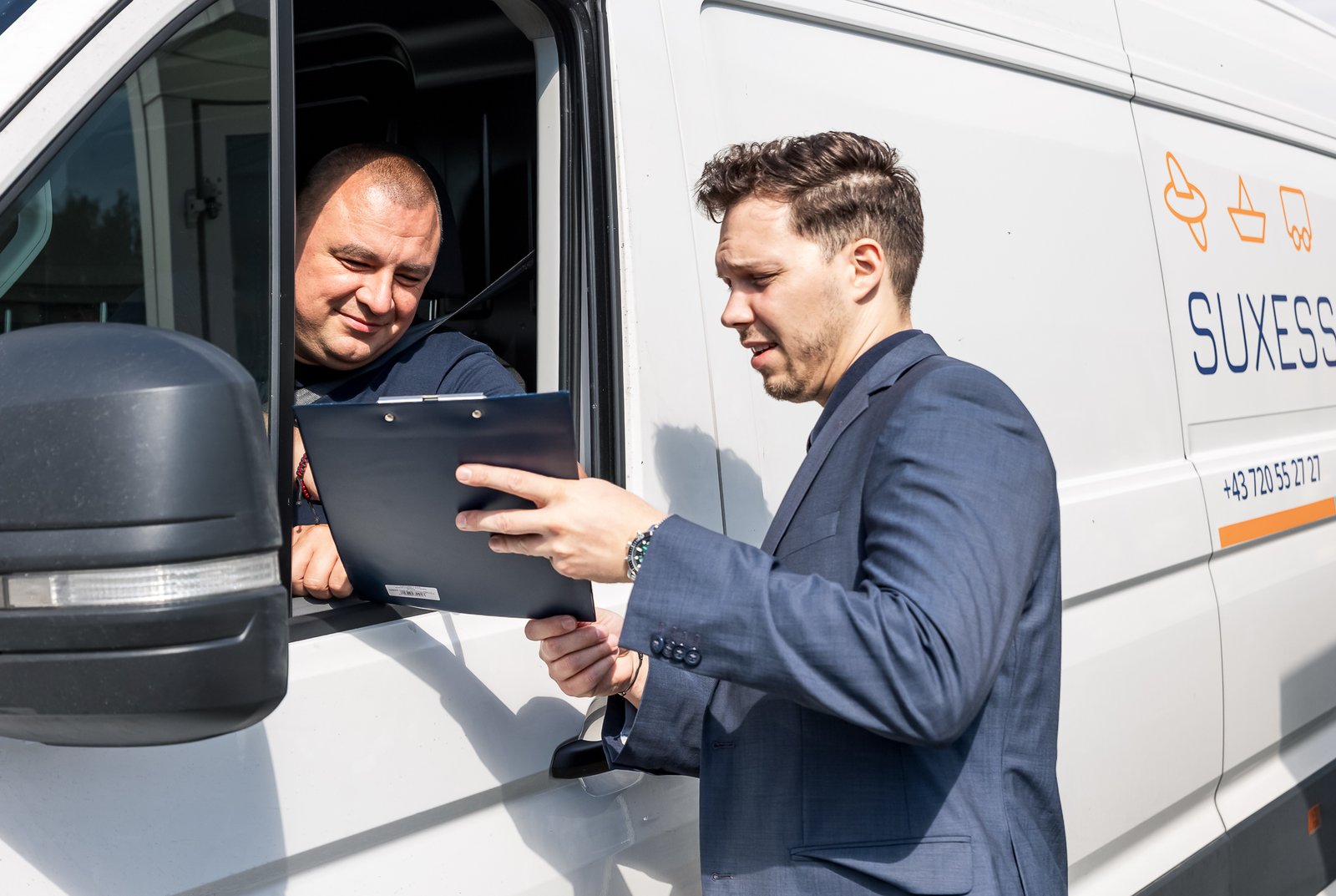 SUXESS LOGISTIC employee going through the paperwork with the driver at the van